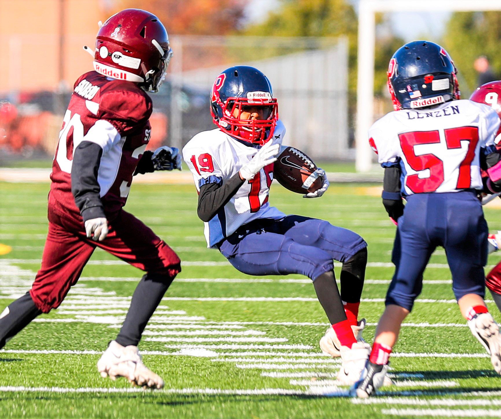 Young American football player running down the field.