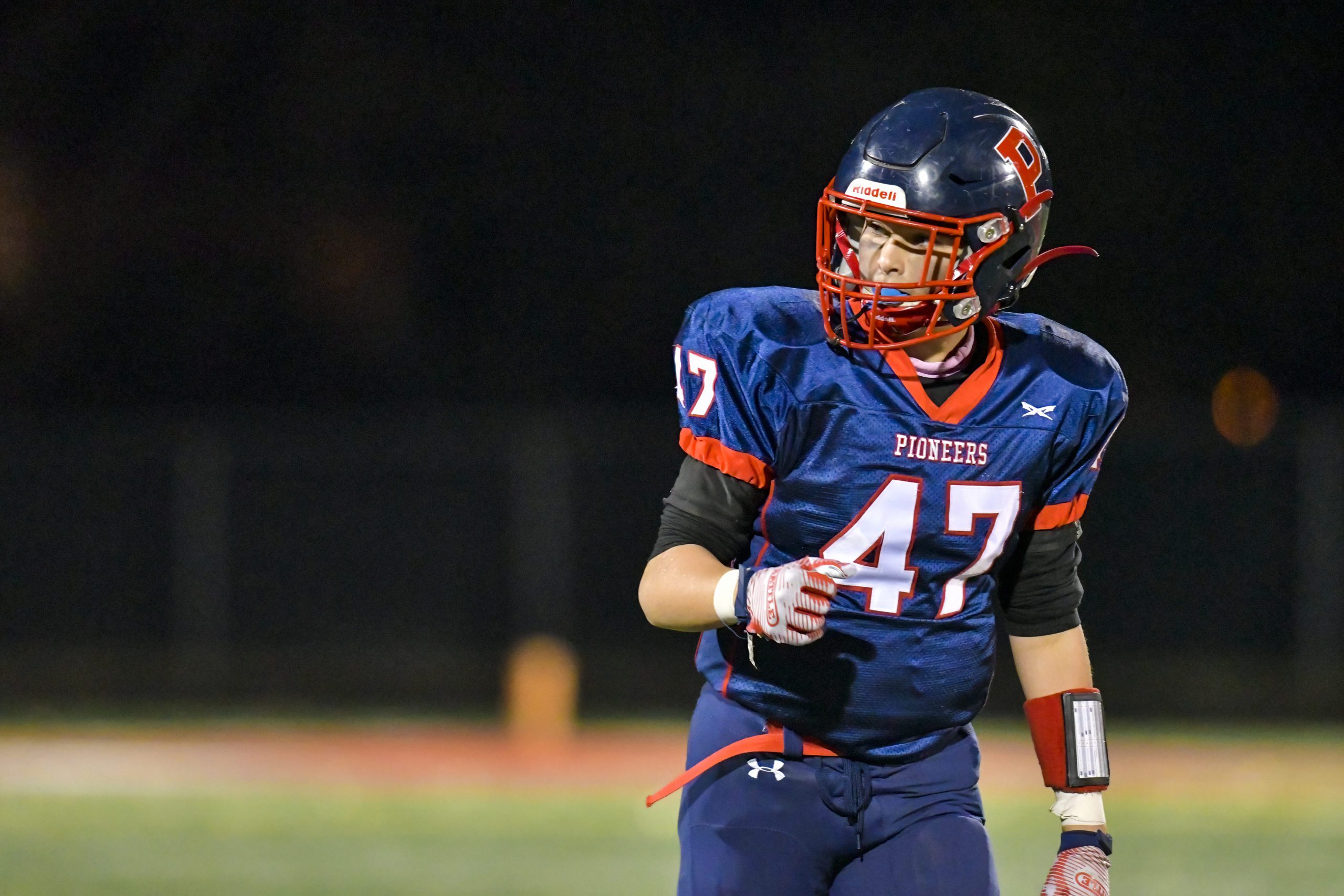 Young American football quarterback standing on a playing field.